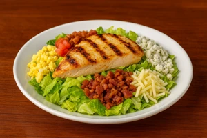Aussie Cobb salad with grilled chicken from Outback Steakhouse featuring fresh lettuce, bacon, eggs, cheese, tomatoes and grilled chicken breast