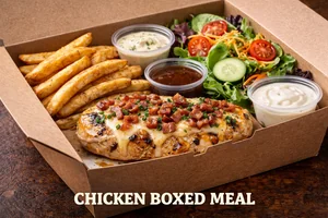 Chicken Boxed Meal featuring grilled chicken breast topped with cheese and bacon, served with seasoned fries, fresh garden salad, and dipping sauces