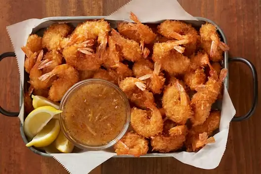 Gold Coast Coconut Shrimp Party Platter featuring crispy coconut-breaded shrimp served with a tangy dipping sauce and fresh lemon wedges.