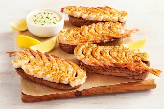 Grilled Shrimp on the Barbie Party Platter featuring seasoned grilled shrimp arranged on toasted bread, served with lemon wedges and a creamy dipping sauce.