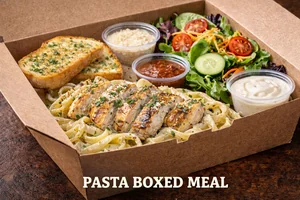 Pasta Boxed Meal featuring creamy chicken alfredo fettuccine served with garlic bread, fresh garden salad, and dipping sauces