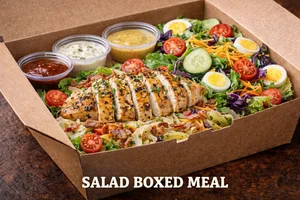 Salad Boxed Meal featuring grilled chicken breast served over fresh mixed greens with bacon, eggs, tomatoes, cheese, and assorted dressings