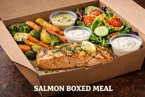 Salmon Boxed Meal featuring grilled salmon fillet with lemon butter, roasted vegetables, fresh garden salad, and dipping sauces
